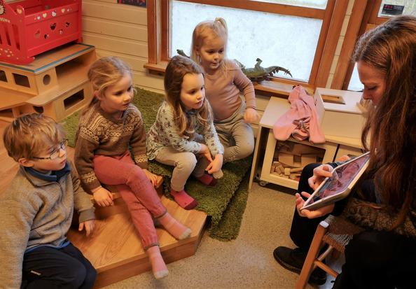  Caspian, Jenny, Sara og Olivia synes det er kjekt når barnehagelærer Anita Viste Eskeland bruker nettbrettet i lesestunden.