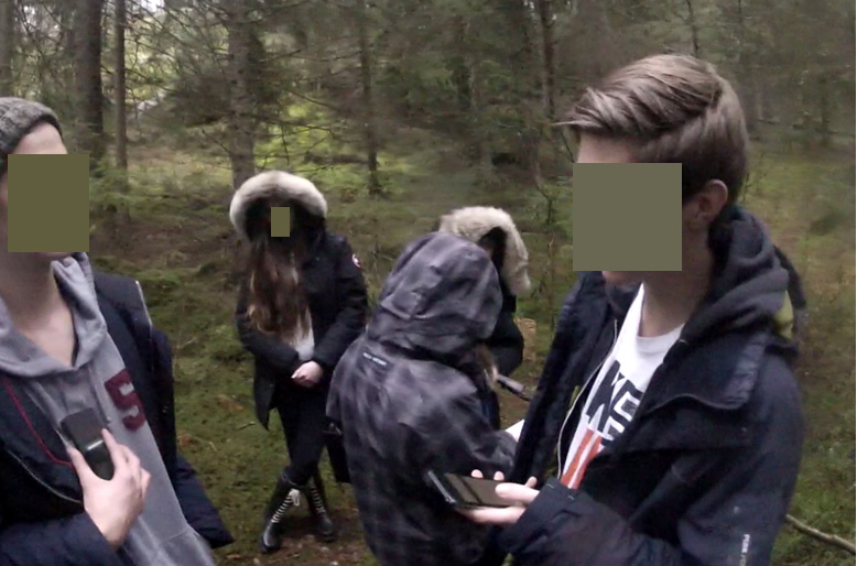 Bilde 1: Bildet viser Jakob og Daniel som bruker mobiltelefonene sine som informasjonskilde. Jannike og Elsa holder posten og står sammen med ei jente fra den andre gruppa.