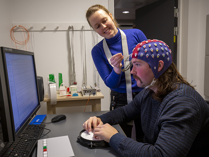 Med hjelp av EEG kan Foldal måle elektrisk aktivitet i hjernen hos deltagere som løser oppgaver mens de lytter til en rytme og avvikende lyder. Foto: Annika Thomson.